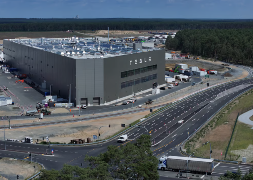 Логото на Тесла виси на фасадата на зграда во фабриката Тесла во близина на Груенхајде, Германија