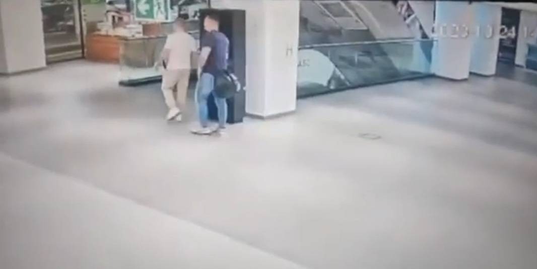 Раде Трајковски (сина облека) и лицето пред да бидат ранети, се движат кон елеваторот